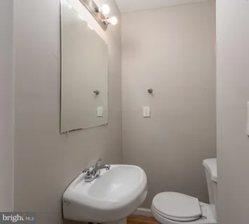 an empty room with wooden floor chandelier fan and closet area