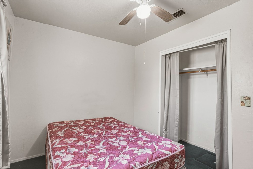 6812 Helton Street Winton, CA 95388 - Photo 19 of 24 a bedroom with a bed and a chandelier