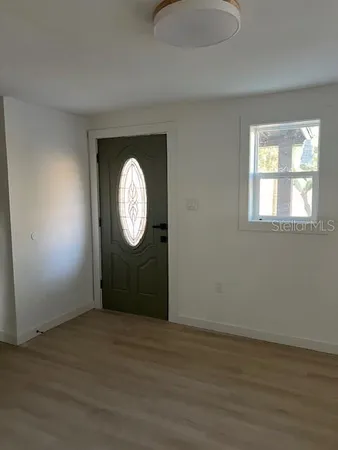 a view of a livingroom with wooden floor and a window