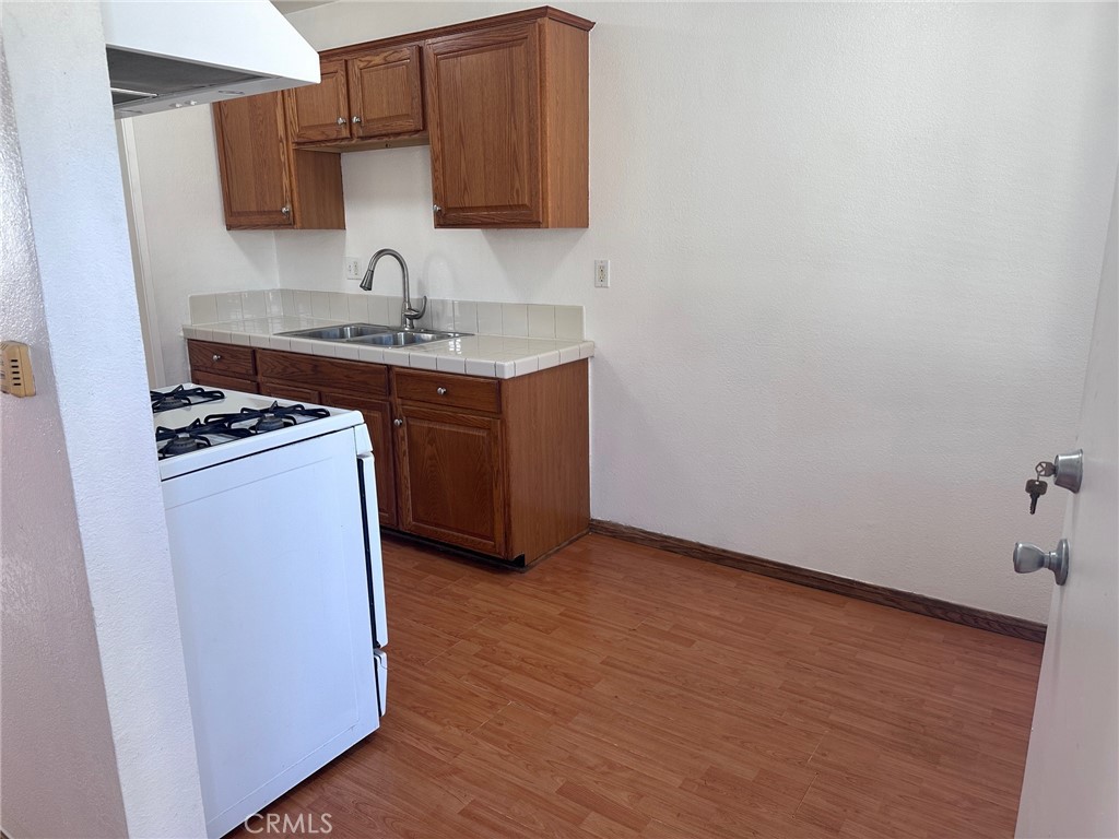 318 East Walnut Street, Unit B Santa Ana, CA 92701 - Photo 3 of 9 a kitchen with granite countertop a sink stove and cabinets