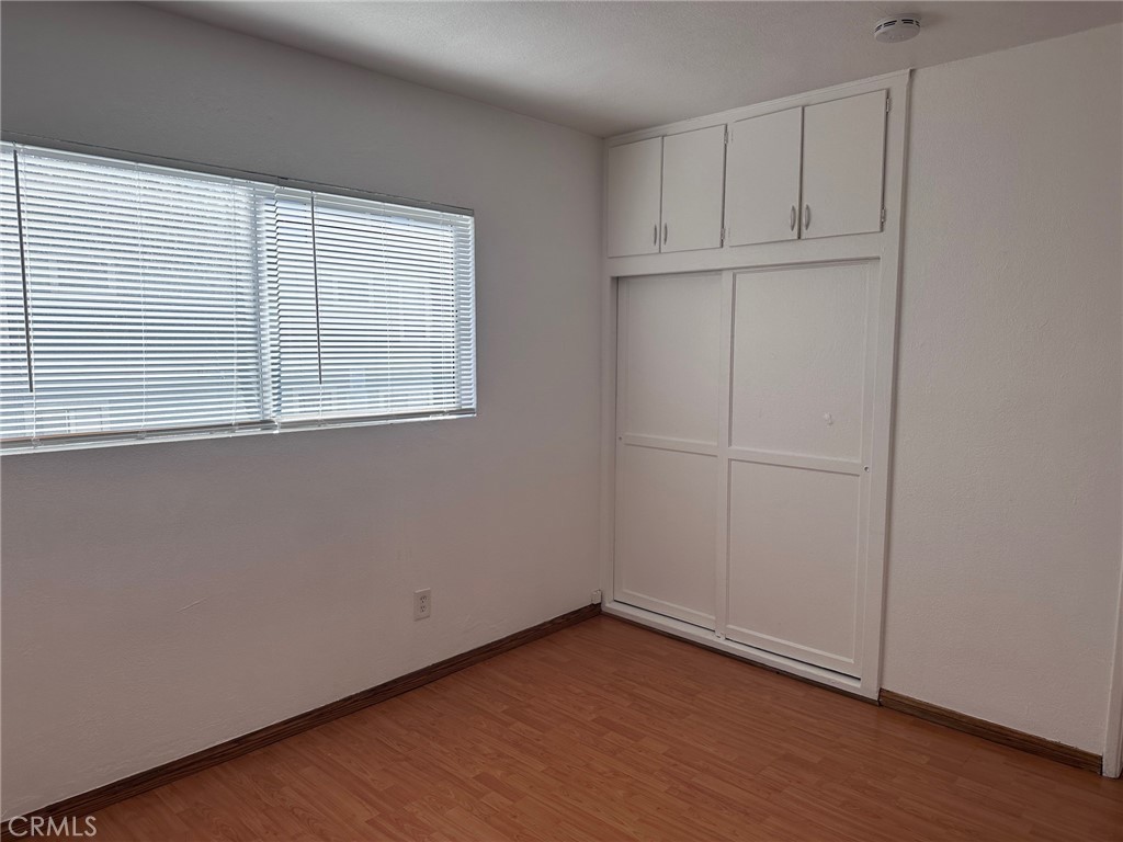 318 East Walnut Street, Unit B Santa Ana, CA 92701 - Photo 6 of 9 an empty room with wooden floor and windows