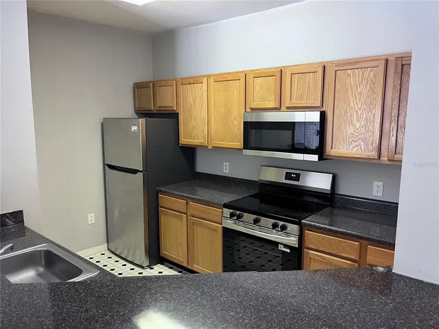 a kitchen with stainless steel appliances a stove microwave and a sink