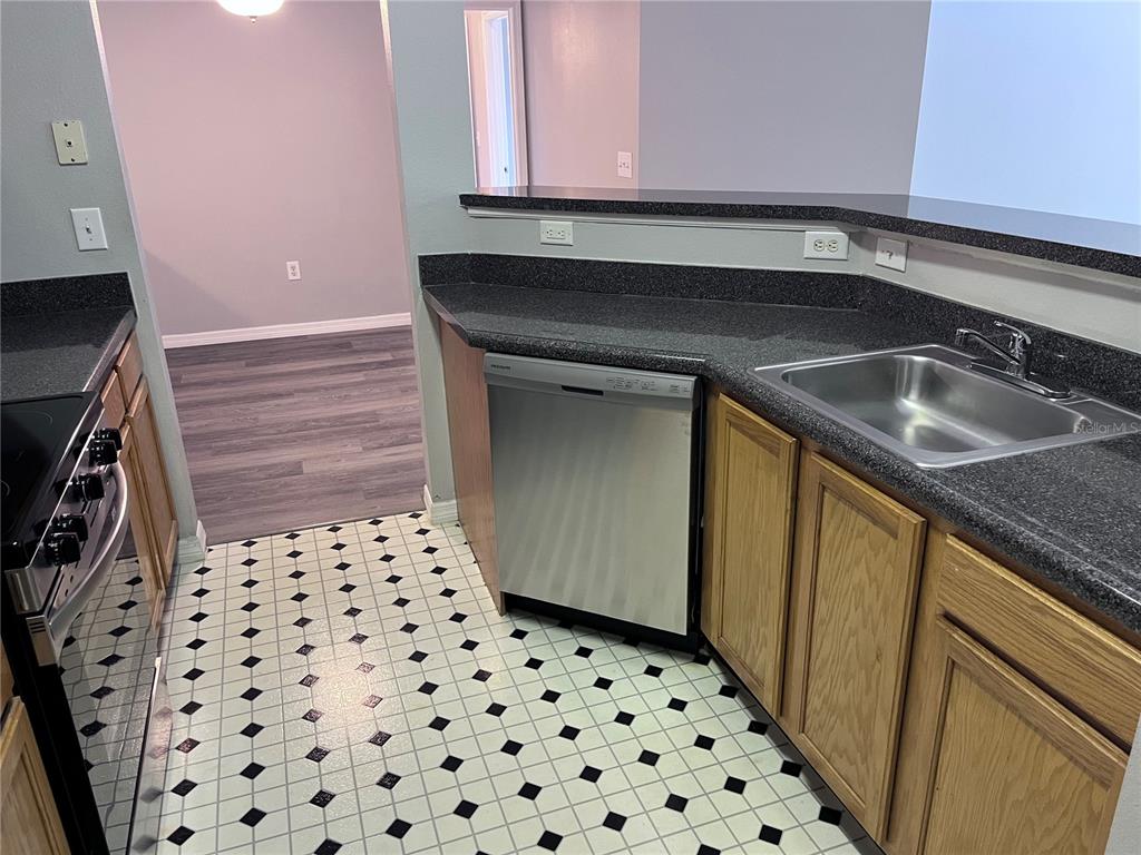 4802 51st Street West, Unit 521 Bradenton, FL 34210 - Photo 5 of 16 a kitchen with granite countertop a sink and a stove top oven