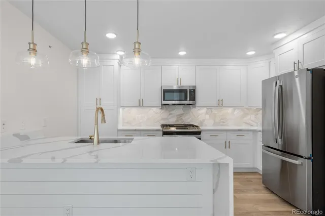a kitchen with stainless steel appliances a refrigerator and a stove top oven