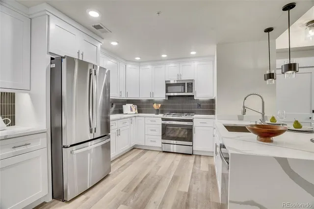 a kitchen with white cabinets and stainless steel appliances