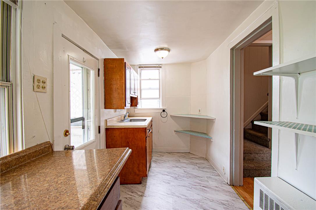 27 West Allen Street Allentown, PA 18102 - Photo 12 of 26 A compact kitchen offers a practical workspace with ample natural light and direct outdoor access.