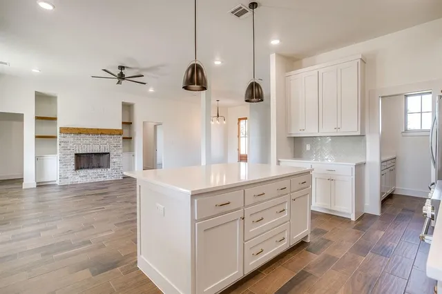 a kitchen with a white cabinets and chandelier