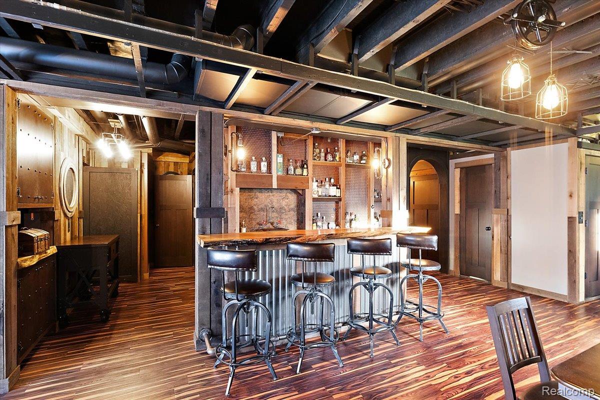 5035 Hidden Ridge Road Metamora, MI 48455 - Photo 55 of 65 Indoor wet bar featuring dark wood-style floors, open shelves, wood counters, arched walkways, and hanging light fixtures