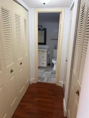 a view of a hallway view with wooden floor and workspace