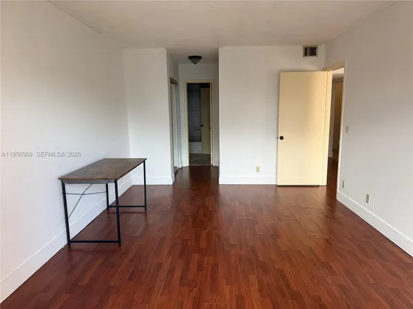 a view of a hallway and wooden floor with a table