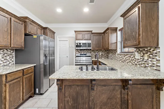 a kitchen with stainless steel appliances granite countertop a sink stove and refrigerator