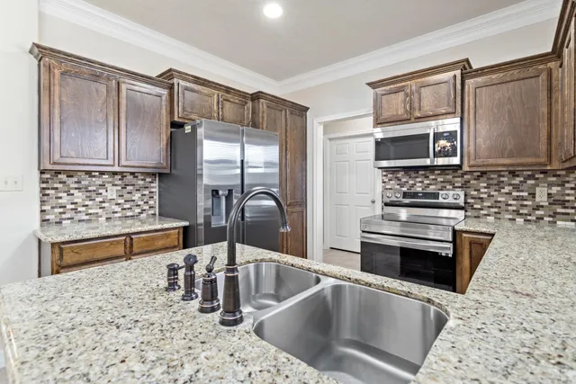 a kitchen with granite countertop a sink and a stove top oven