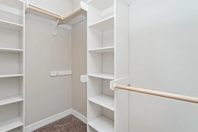 a view of walk in closet with empty racks