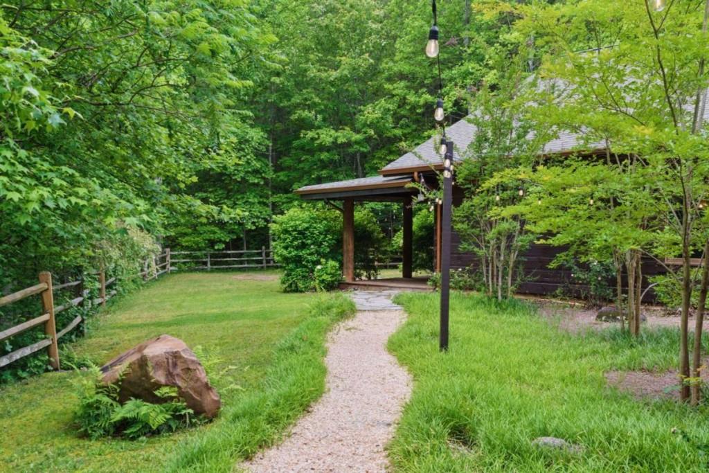 230 Old Mill White Road Jasper, GA 30143 - Photo 58 of 65 a backyard of a house with table and chairs potted plants and large tree