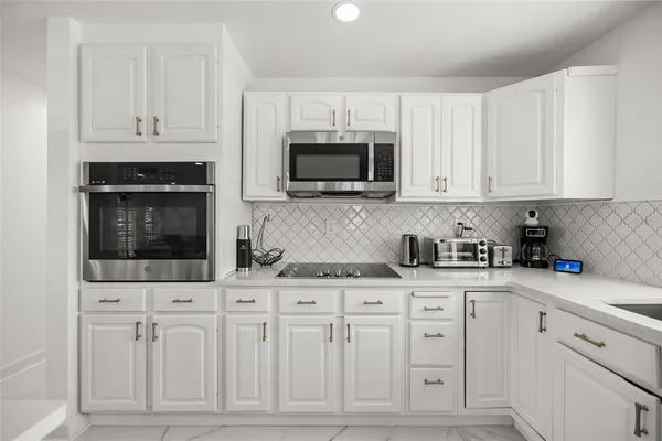 a large kitchen with stainless steel appliances lots of counter top space cabinets and a refrigerator