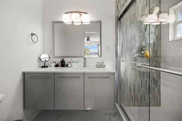 a bathroom with a shower sink and mirror