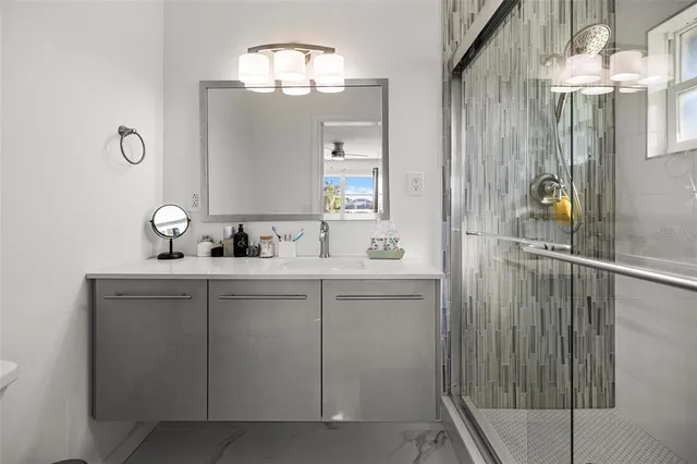 a bathroom with a shower sink and mirror