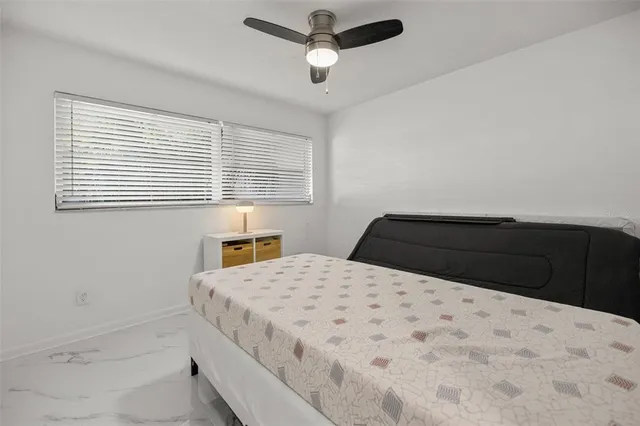 a bedroom with two beds and ceiling fan
