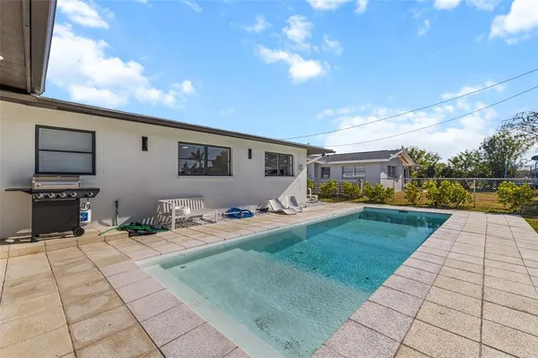 a view of swimming pool with outdoor seating and plants