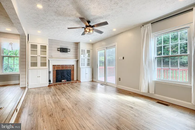a view of empty room with wooden floor and fireplace