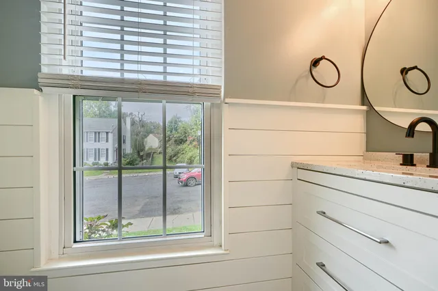an empty room with wooden floor fireplace and windows