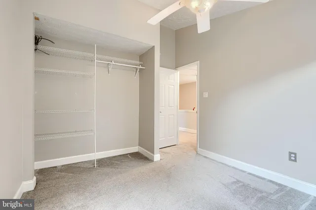 an empty room with a window and a fan