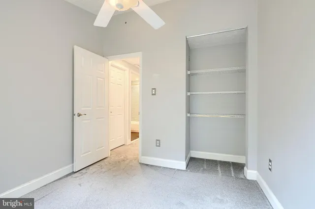 an empty room with a window and a fan