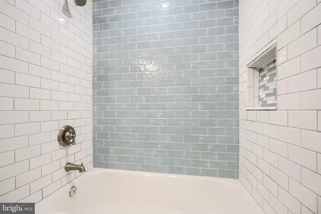 a bathroom with a sink a toilet a mirror and shower