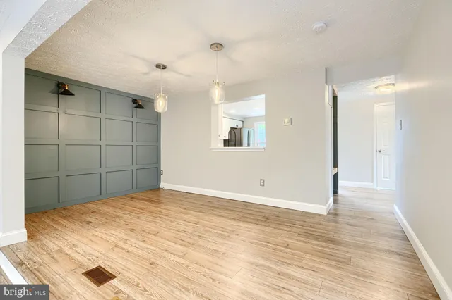 an empty room with wooden floor and mirror