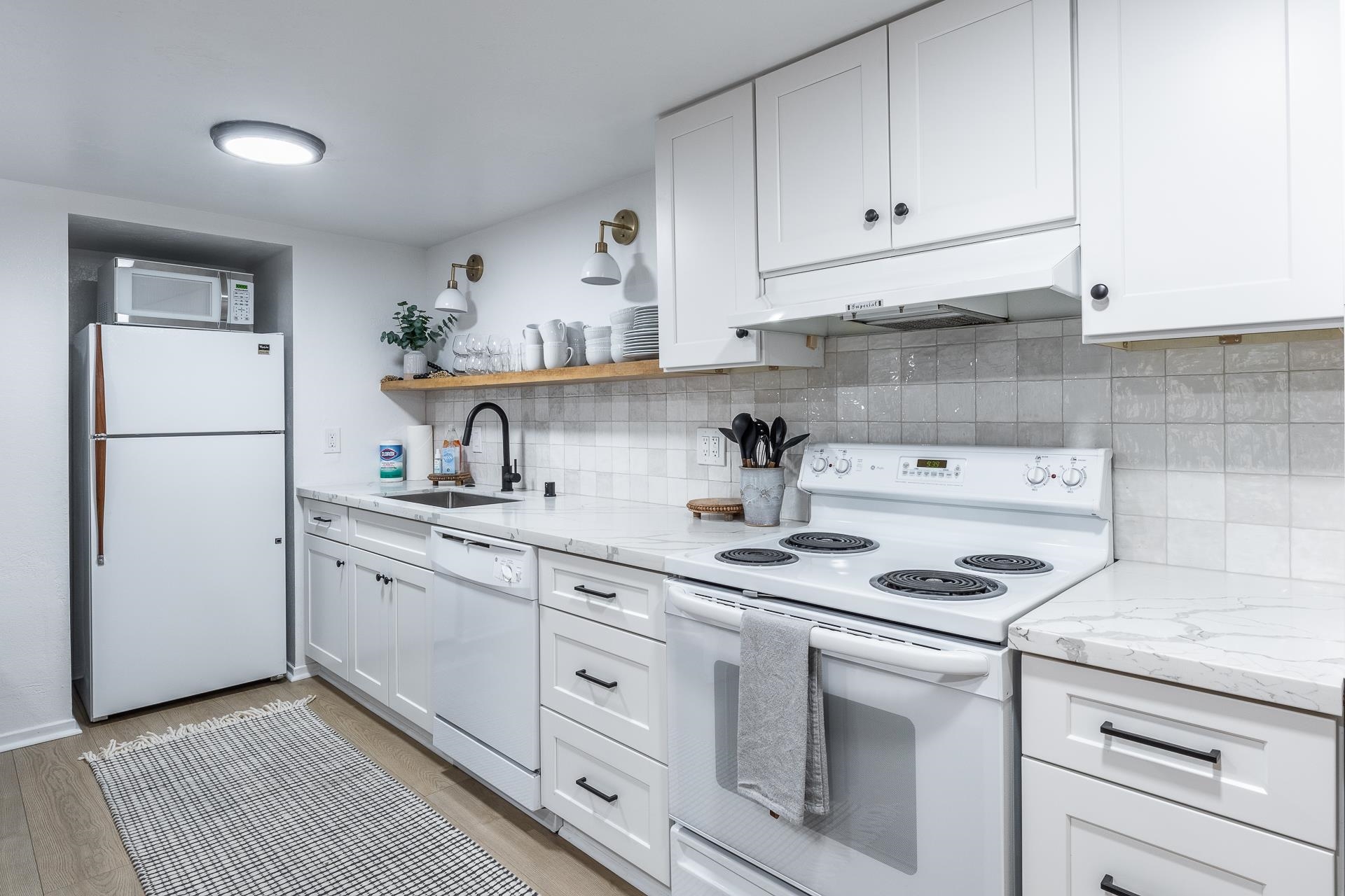 2289 Sierra Nevada Road, Unit J8 Mammoth Lakes, CA 93546 - Photo 11 of 30 Kitchen featuring white appliances, open shelves, light stone counters, backsplash, and white cabinets