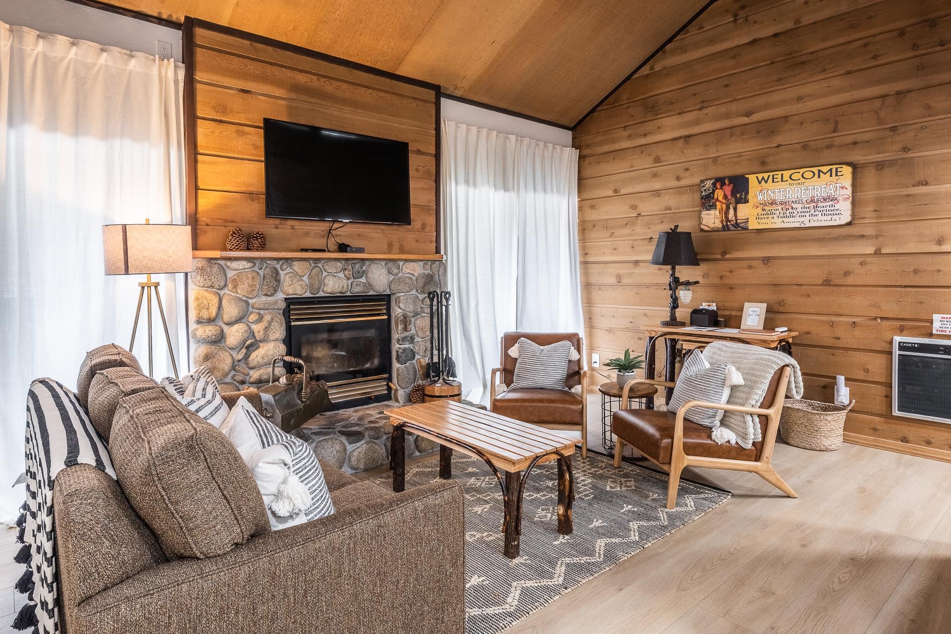 2289 Sierra Nevada Road, Unit J8 Mammoth Lakes, CA 93546 - Photo 21 of 30 Living room with heating unit, wooden walls, wood finished floors, a vaulted wooden ceiling, and a stone fireplace
