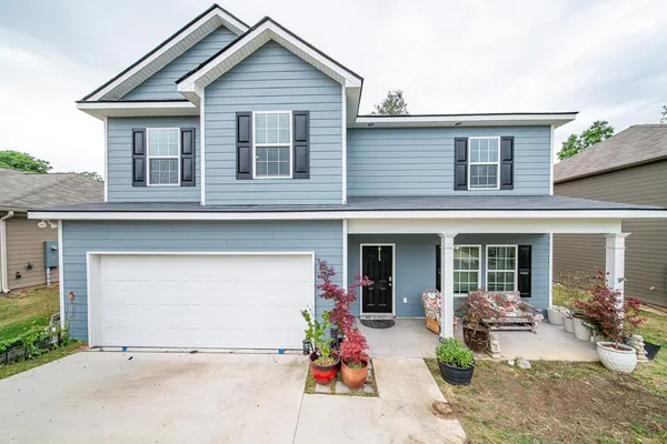 a front view of a house with outdoor seating and a garage