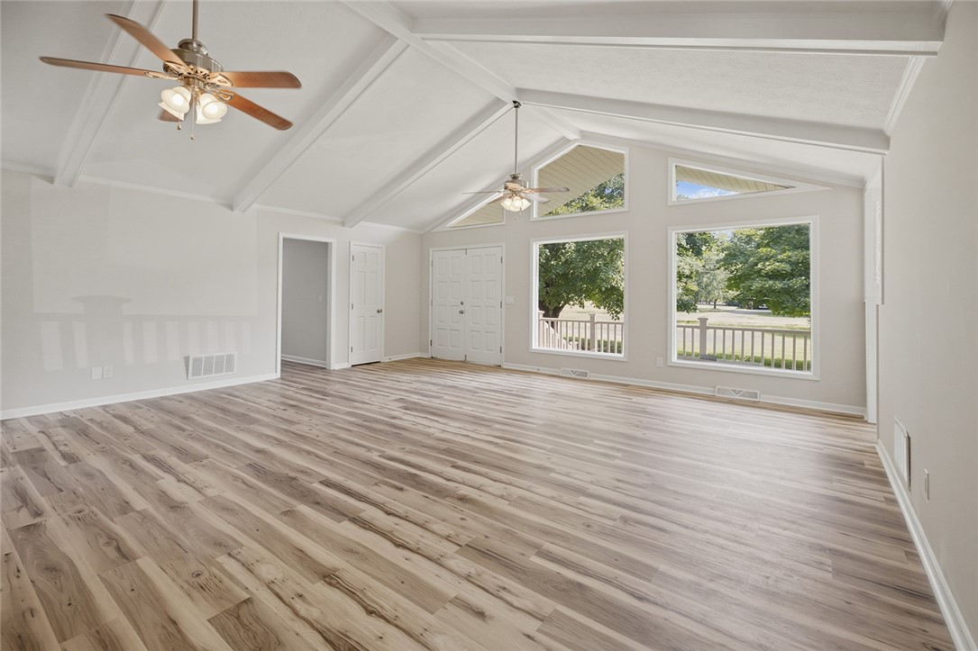 902 Cherokee Road Pelzer, SC 29669 - Photo 5 of 38 The generously proportioned living area boasts soaring vaulted ceilings and expansive windows, creating an airy, light-filled environment.