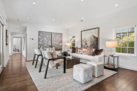 a living room with furniture a wooden floor and a large window