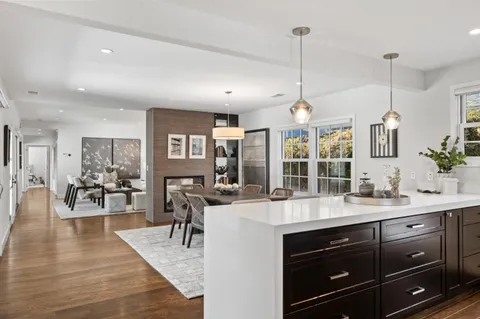 a very nice looking dining room with wooden floor and furniture