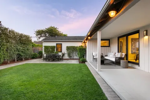 a view of a house with backyard sitting area and garden