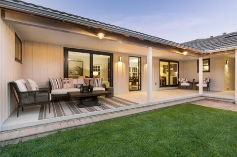 a view of a patio with couches chairs and a big yard