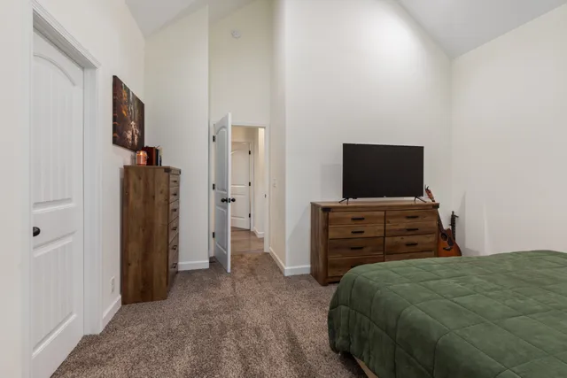 a bedroom with a bed and flat tv screen on wall