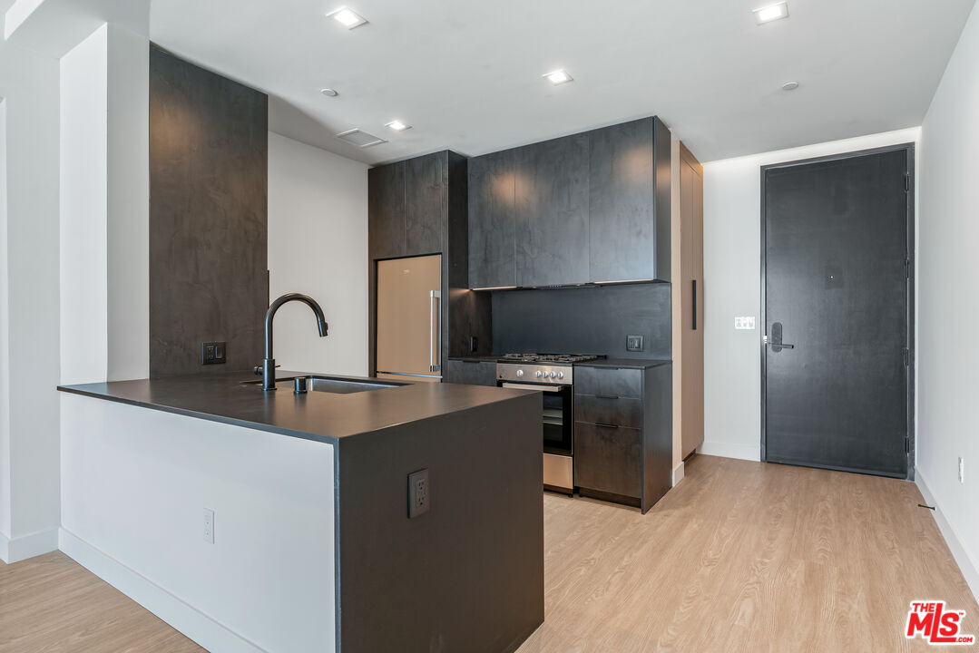 3688 Overland Avenue, Unit PH21 Los Angeles, CA 90034 - Photo 2 of 14 a kitchen with stainless steel appliances a sink a stove and refrigerator