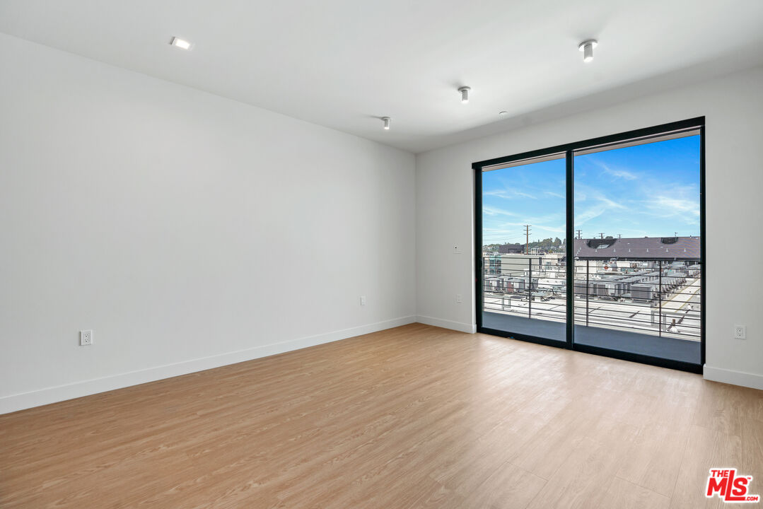 3688 Overland Avenue, Unit PH21 Los Angeles, CA 90034 - Photo 5 of 14 a view of an empty room with wooden floor and a window