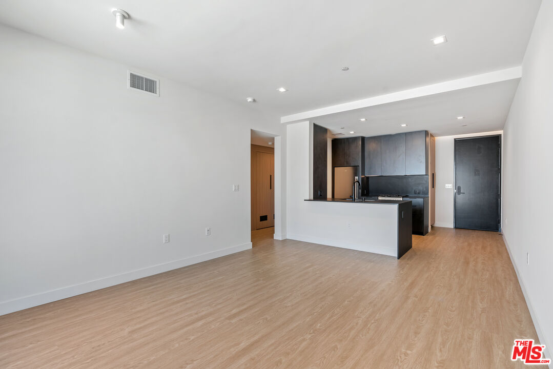 3688 Overland Avenue, Unit PH21 Los Angeles, CA 90034 - Photo 6 of 14 a view of kitchen with refrigerator microwave and wooden floor