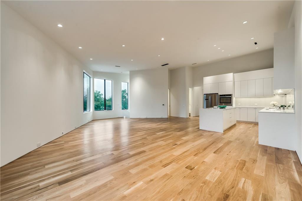 1504 Burlew Street, Unit 4 Dallas, TX 75204 - Photo 15 of 30 a view of a kitchen with kitchen island a sink wooden floor and a refrigerator