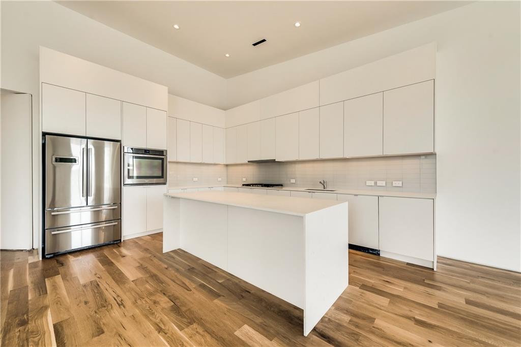 1504 Burlew Street, Unit 4 Dallas, TX 75204 - Photo 7 of 30 a kitchen with granite countertop white cabinets and stainless steel appliances