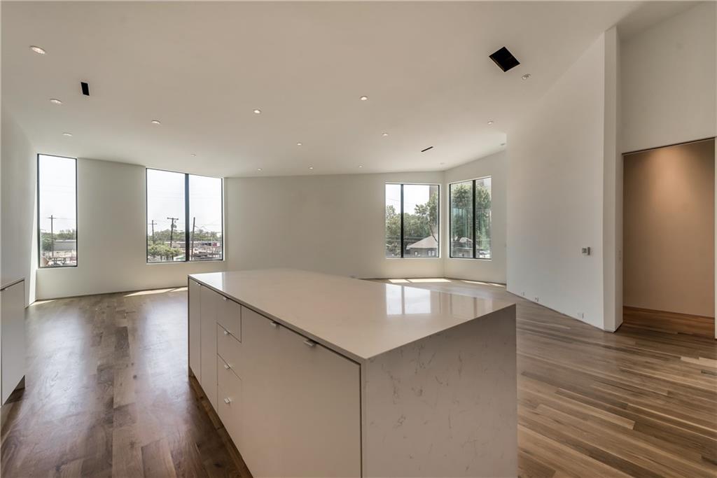 1504 Burlew Street, Unit 4 Dallas, TX 75204 - Photo 9 of 30 a room with kitchen island stainless steel appliances wooden floor and window