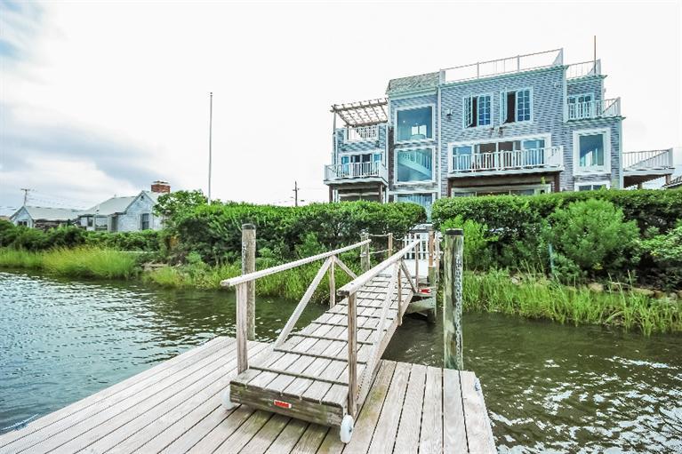 a view of a lake with a yard and large buildings