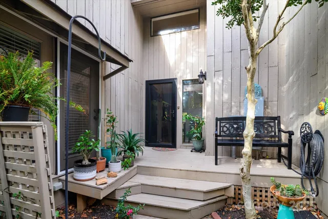 a view of backyard with outdoor seating and potted plants