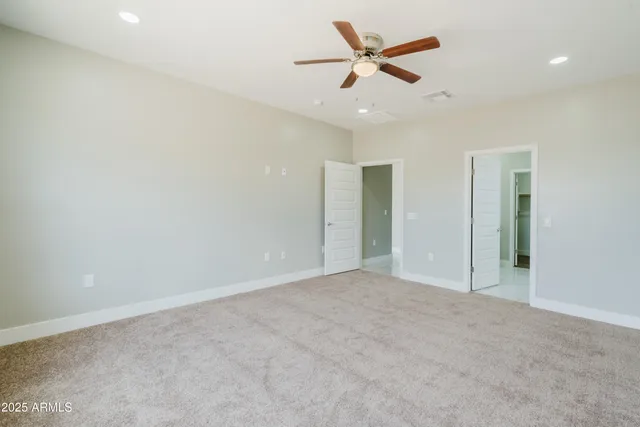 an empty room with ceiling fan and window