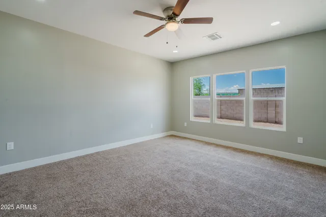 an empty room with a window and ceiling fan