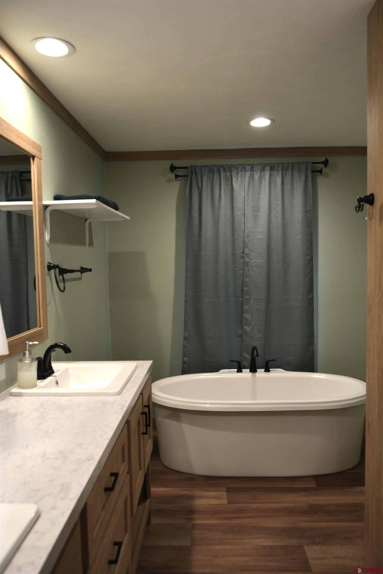 901 6530 Road, Unit 1030 Montrose, CO 81401 - Photo 11 of 22 a bathroom with a bathtub and sink
