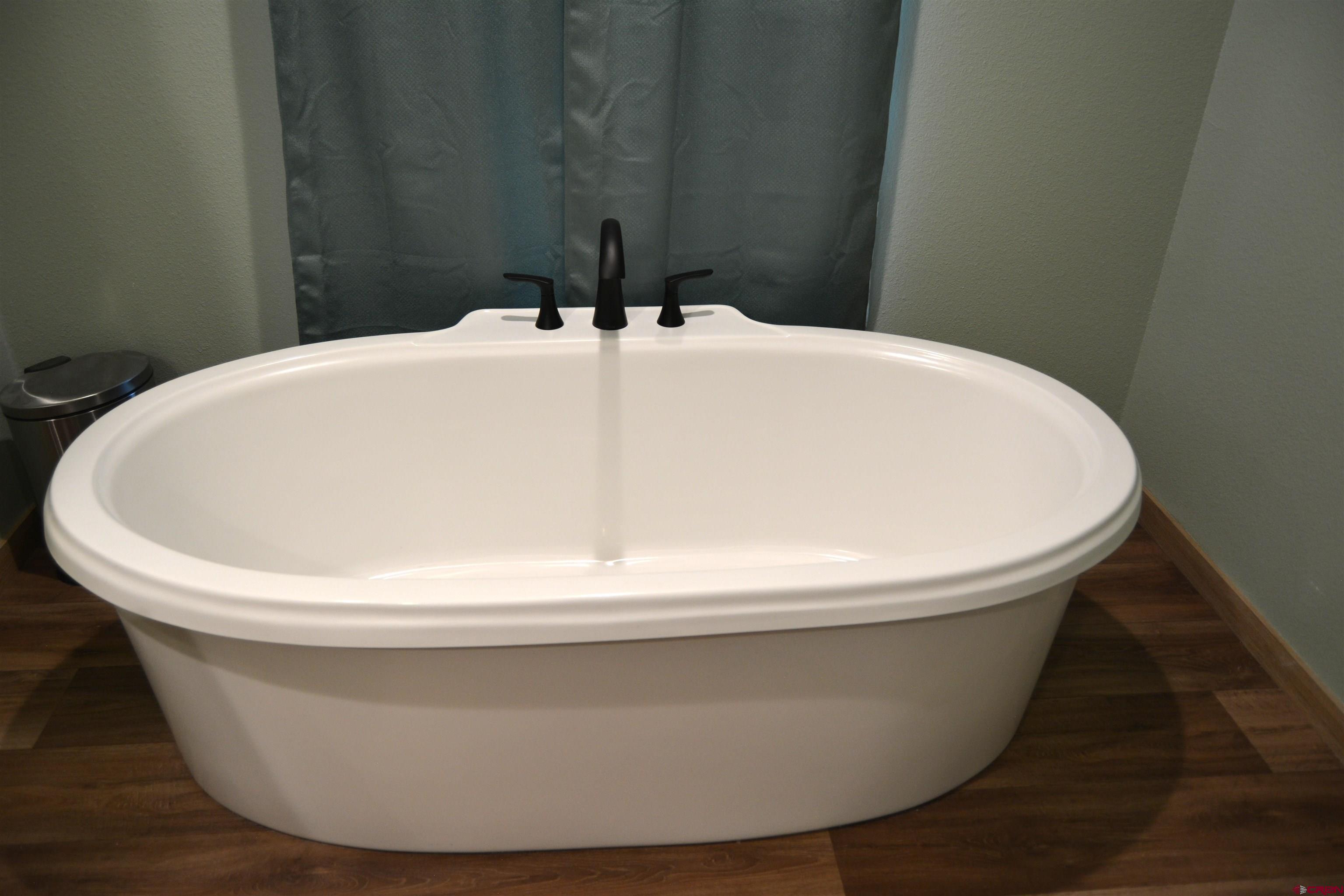 901 6530 Road, Unit 1030 Montrose, CO 81401 - Photo 13 of 22 a white white tub sitting in a bathroom